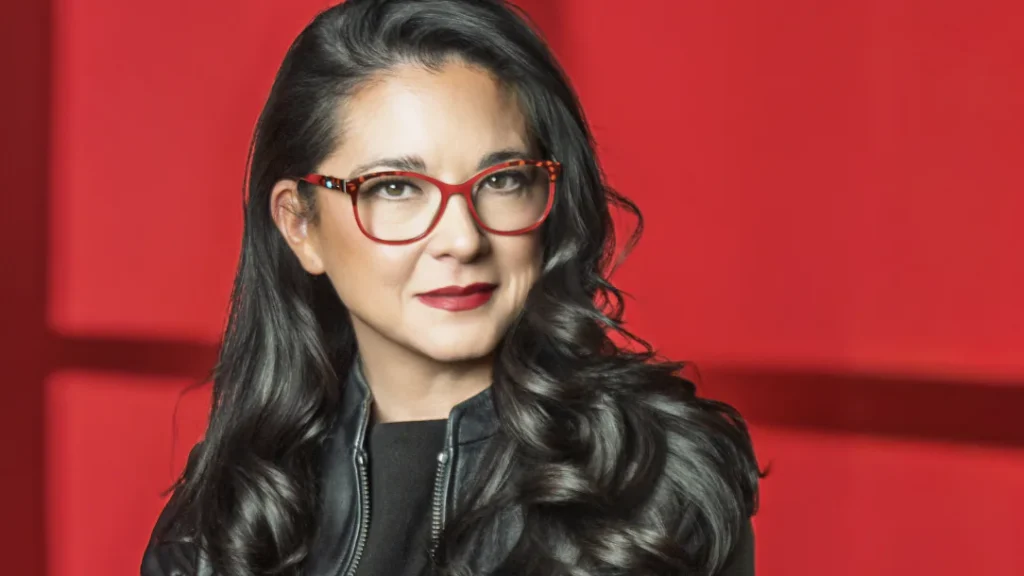 Dr. Vonda Wright, orthopedic surgeon, in red glasses against a red backdrop