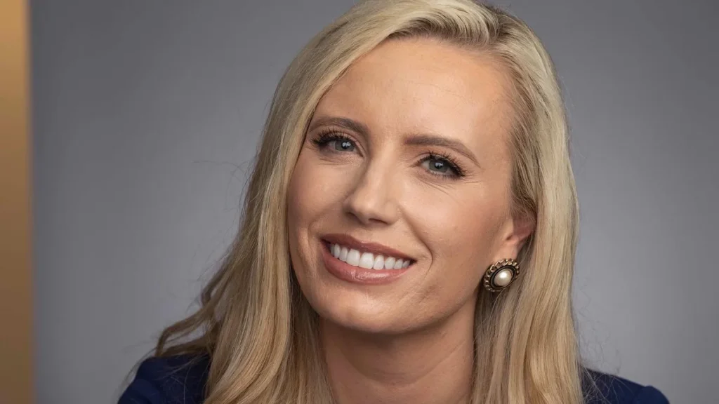Alexandra Hudson, author, smiling in a studio portrait with blonde hair and pearl earrings