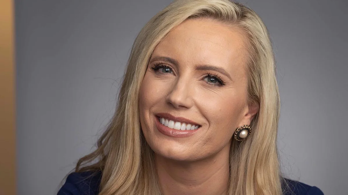 Alexandra Hudson, author, smiling in a studio portrait with blonde hair and pearl earrings