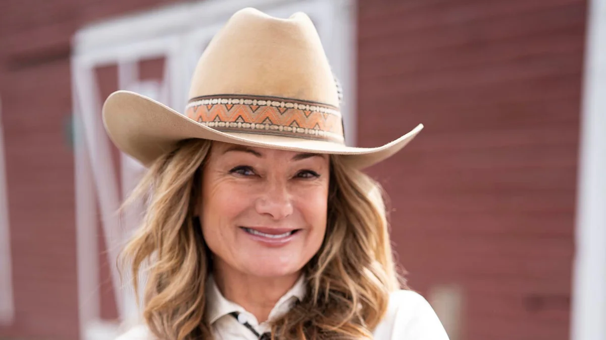 Chantal 'Charlie' Henderson in a cream cowboy hat and white shirt in front of a red barn