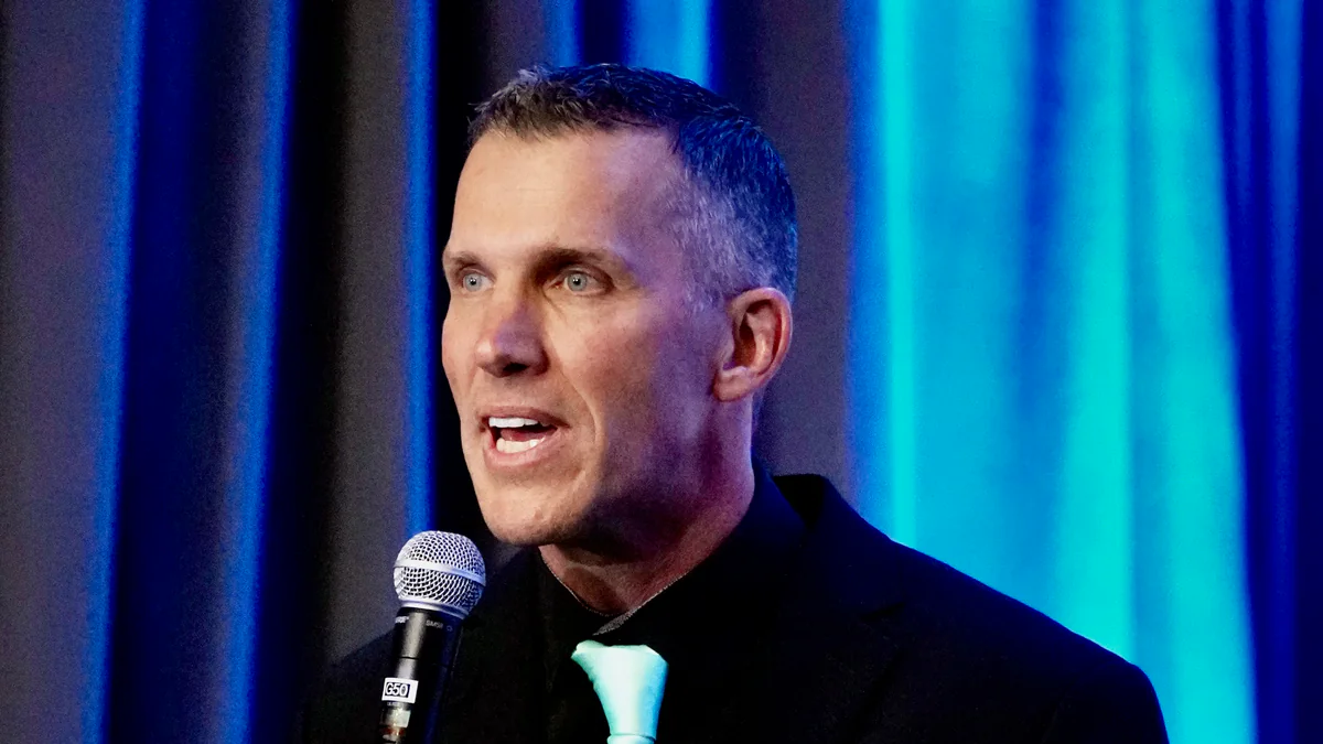 Clinton Phillips, South African-born healthcare founder, speaking into a microphone on stage