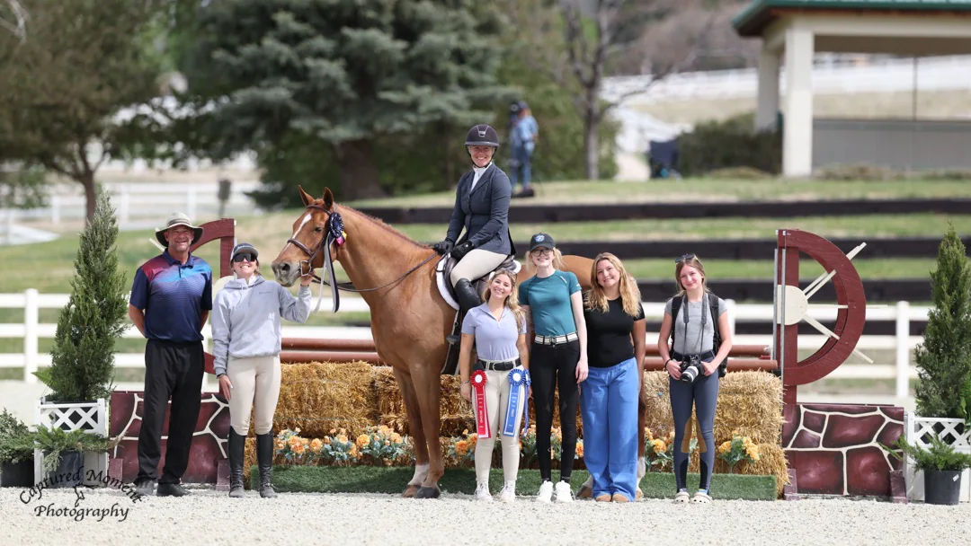 Twin Acres riders lined up with a horse at a hunter-jumper show ring